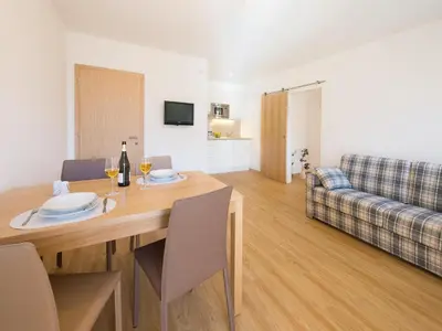 a dining room with a table and a couch at Apartment in Dorf Tirol near tennis court in Tirolo
