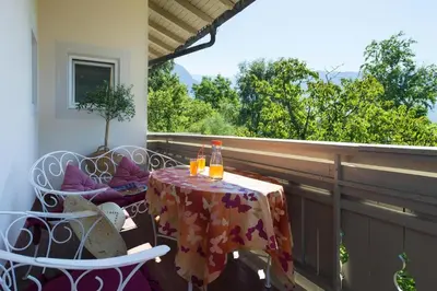 a table and chairs on a balcony with a table and drinks at Apartment in Dorf Tirol near tennis court in Tirolo