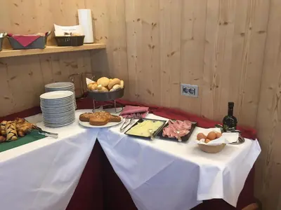 a table with a white table cloth and food on it at Hotel Alemagna in San Vito di Cadore