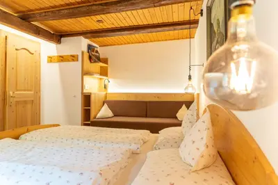a bedroom with two beds and a couch at Ganoihof apartments in Funes