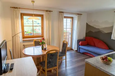 a living room with a table and a couch at Ganoihof apartments in Funes