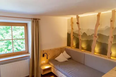 a room with a bench in front of a window at Ganoihof apartments in Funes