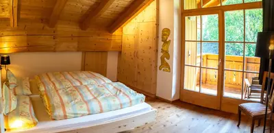 a bedroom with a bed in a log cabin at Ganoihof apartments in Funes