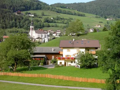 a small village in the mountains with a church at Ganoihof apartments in Funes