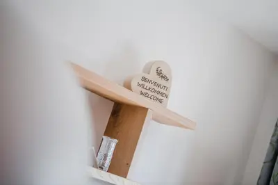 a wooden cross on a wall with a sign on it at Residence Erika - Apartments, Breakfast & Sauna in Siusi