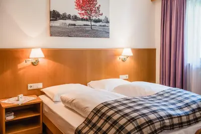 a bed in a hotel room with two pillows at Residence Erika - Apartments, Breakfast & Sauna in Siusi