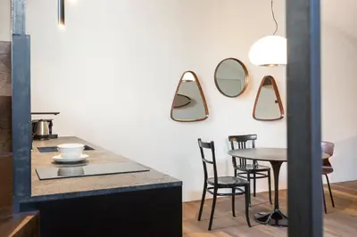 a kitchen with a table and mirrors on the wall at Goldenstern Townhouse in Bolzano