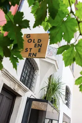 a sign on a building that reads olden sing im at Goldenstern Townhouse in Bolzano