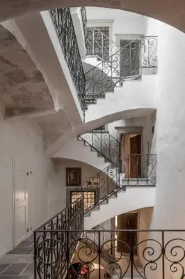 a staircase in a house with white walls and black railings at Goldenstern Townhouse in Bolzano