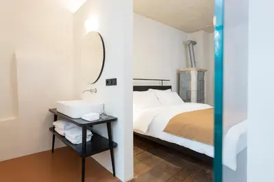 a bedroom with a bed and a sink and a mirror at Goldenstern Townhouse in Bolzano