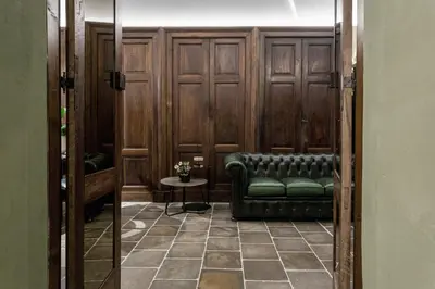 a room with a green couch and a table at Goldenstern Townhouse in Bolzano