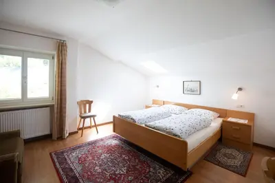 two beds in a white room with a window at Appartements Martinsheim in Tirolo
