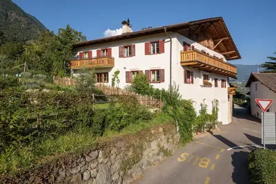 a house on a hill next to a road at Unterdornerhof in Lagundo