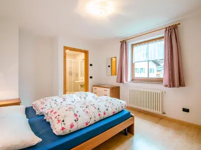 a bedroom with a bed with a blue comforter at Apartment Trottner by Interhome in Mazzin