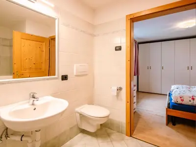 a bedroom with a bed and a white cabinet at Apartment Trottner by Interhome in Mazzin