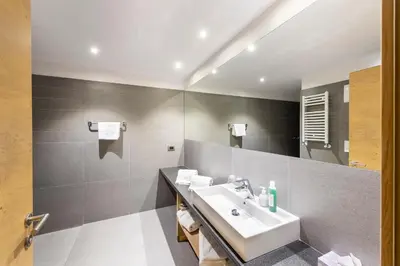 a bathroom with a sink and a mirror at Design & Suite Hotel Ciarnadoi in Vigo di Fassa