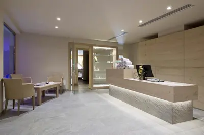 a lobby with a counter and a table and chairs at Design & Suite Hotel Ciarnadoi in Vigo di Fassa