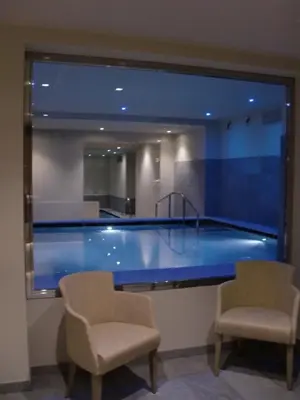 a large aquarium in a room with two chairs at Design & Suite Hotel Ciarnadoi in Vigo di Fassa