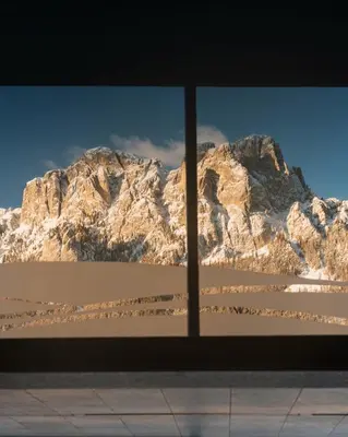 a view of a mountain through a window at Design & Suite Hotel Ciarnadoi in Vigo di Fassa