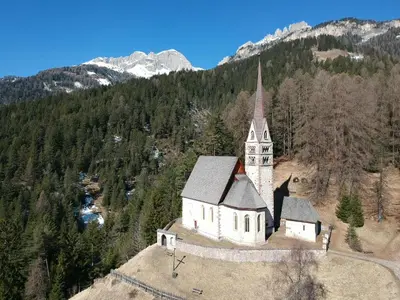 a large white building with a roof at Ciasa Weiss in Vigo di Fassa