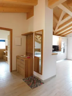 a kitchen with wooden cabinets and a white refrigerator at Ciasa Weiss in Vigo di Fassa