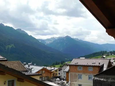 a bedroom with a bed in a room with wooden walls at Ciasa Weiss in Vigo di Fassa