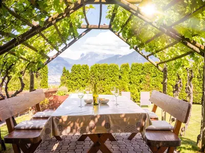 a house in a field with flowers in the foreground at Ferienwohnung Haas in Appiano sulla Strada del Vino