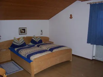 a bedroom with a wooden bed with blue pillows at Mairhof in Laion