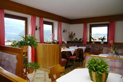 a restaurant with tables and chairs and windows at Mairhof in Laion