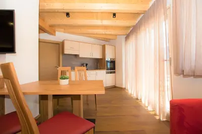 a kitchen and dining room with a wooden table at Villa Residence Franziskus in Tirolo