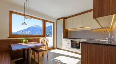 a kitchen with a table and a large window at Villa Residence Franziskus in Tirolo