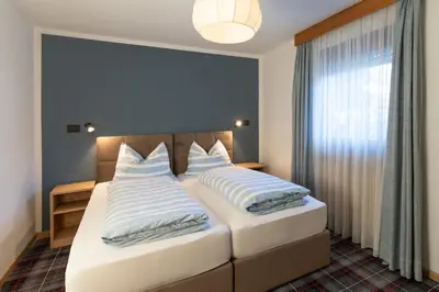 a bedroom with a bed with blue and white pillows at Chalet Fisti in La Villa