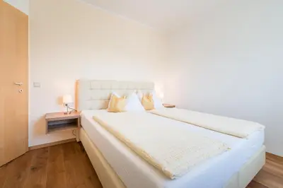 a white bedroom with a large white bed with two pillows at Ferienwohnungen Zwerger Reinhold in Termeno