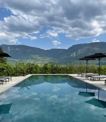 a swimming pool with a view of the mountains at Ferienwohnungen Zwerger Reinhold in Termeno