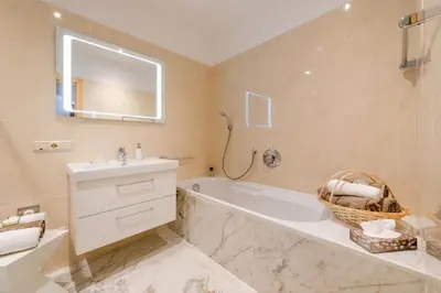 a bathroom with a tub and a sink and a mirror at Ferienwohnungen Zwerger Reinhold in Termeno