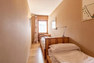 a room with two beds and a window at Ca' Milijera in Cortina dʼAmpezzo