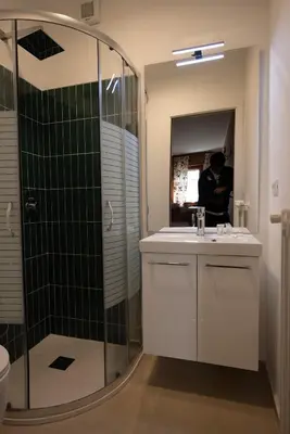a bathroom with a shower and a sink and a mirror at Ca' Milijera in Cortina dʼAmpezzo