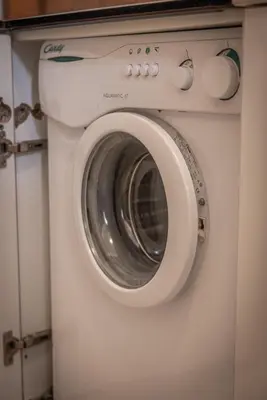 a white washing machine in a kitchen with a door at Ca' Milijera in Cortina dʼAmpezzo