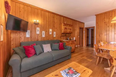 a living room with a couch and a table at Ca' Milijera in Cortina dʼAmpezzo