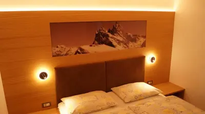 a bedroom with a bed with a picture above it at Apartments Salieta in Santa Cristina in Val Gardena