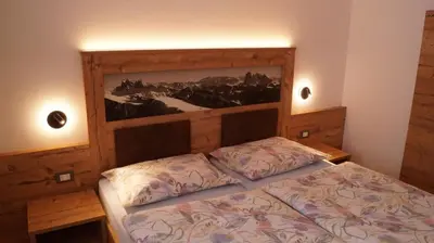 a bedroom with a bed and a painting on the wall at Apartments Salieta in Santa Cristina in Val Gardena