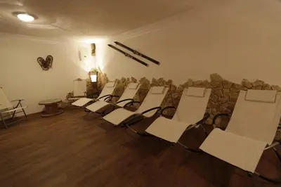 a group of chairs in a room with a stone wall at Apartments Salieta in Santa Cristina in Val Gardena