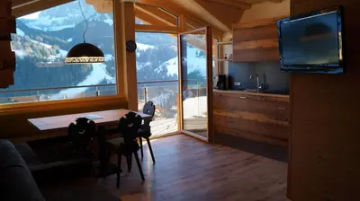 a living room with a table and a large window at Apartments Salieta in Santa Cristina in Val Gardena