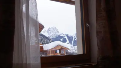 a window with a view of a snow covered mountain at Apartments Salieta in Santa Cristina in Val Gardena