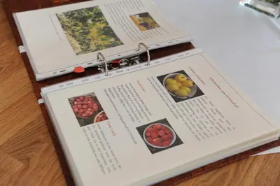 a book with photographs of fruit on it on a table at Urbanhof Prantenberger in Bolzano