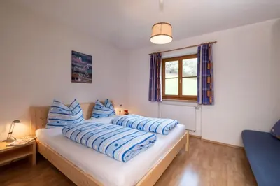 a bedroom with two beds with blue and white pillows at Apartments Dolomites 