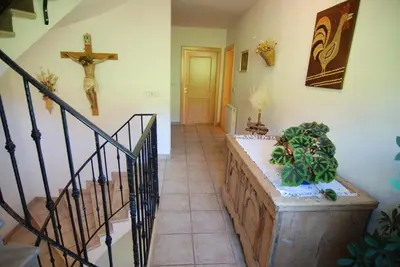 a hallway with a staircase with a cross on the wall at Apartments Dolomites 
