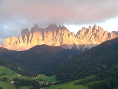 a view of a large mountain range with trees at Apartments Dolomites 
