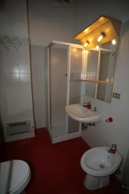 a bathroom with a shower and a toilet and a sink at Residence Anny in Canazei