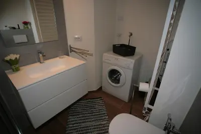 a bathroom with a sink and a washing machine at Residence Anny in Canazei